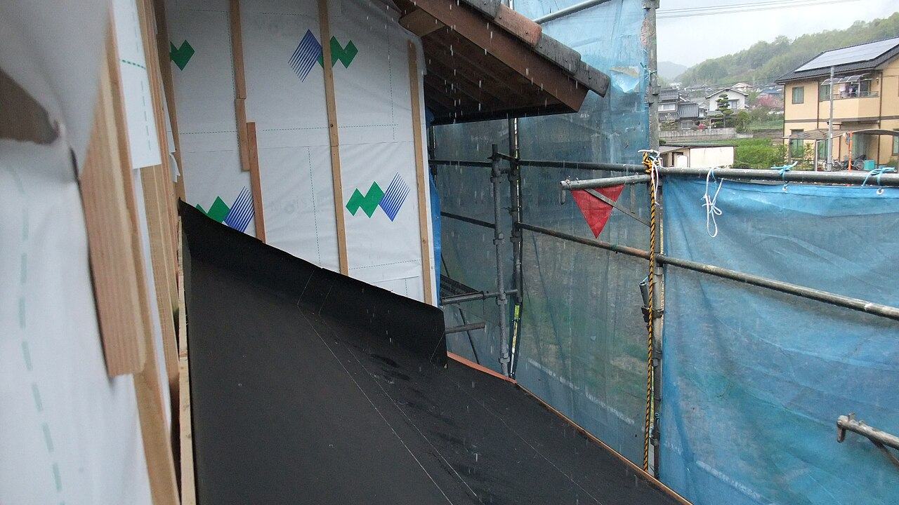 Wet black roofing membrane on an open deck in the rain