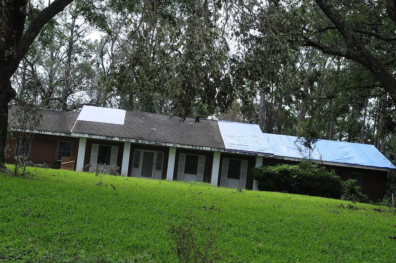 Blue tarp on a brick house roof after a storm